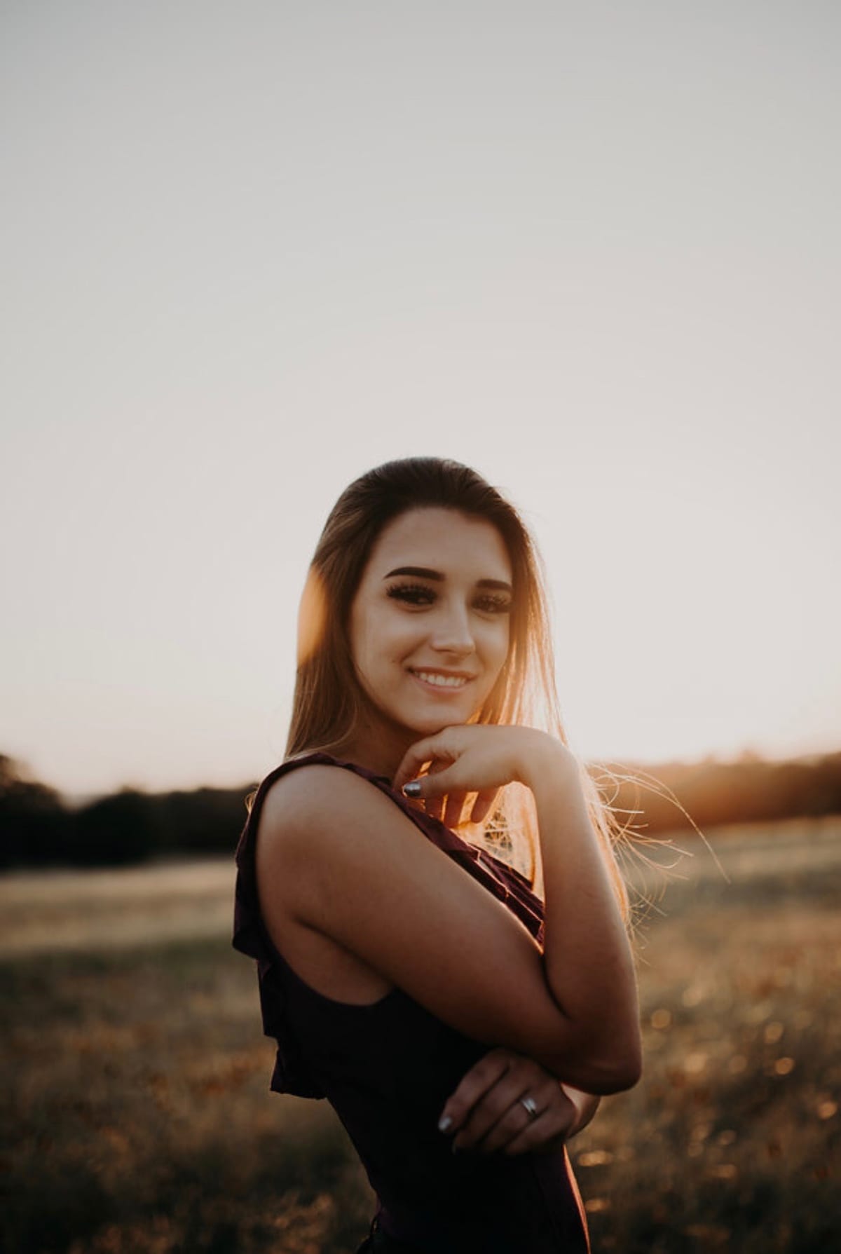 Bella smiling in a field at golden hour