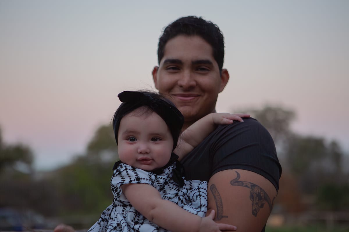 A father holding his baby daughter at dusk