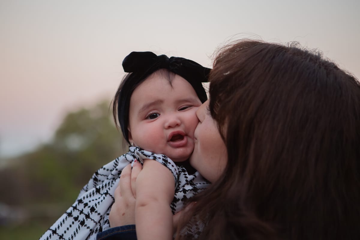 A mother kissing her baby’s cheek