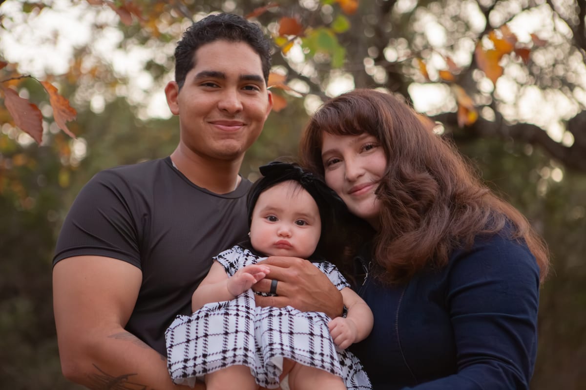 Parents smiling with their baby between them