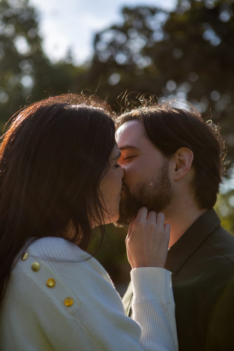 A couple sharing a kiss among the trees
