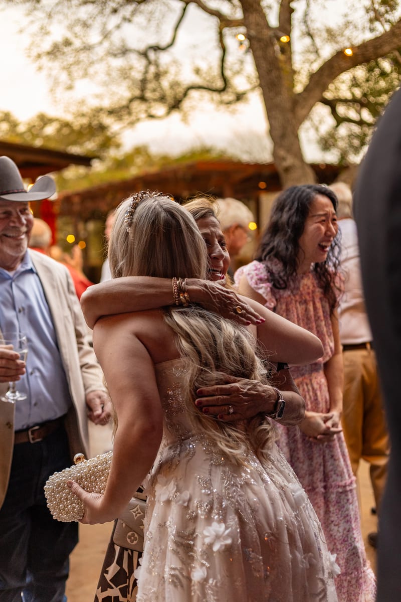 Two guests embracing at a celebration