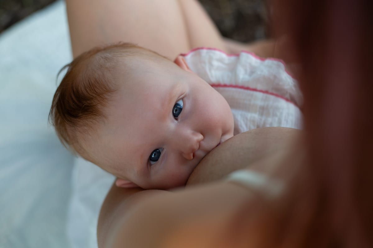 A baby resting against a parent