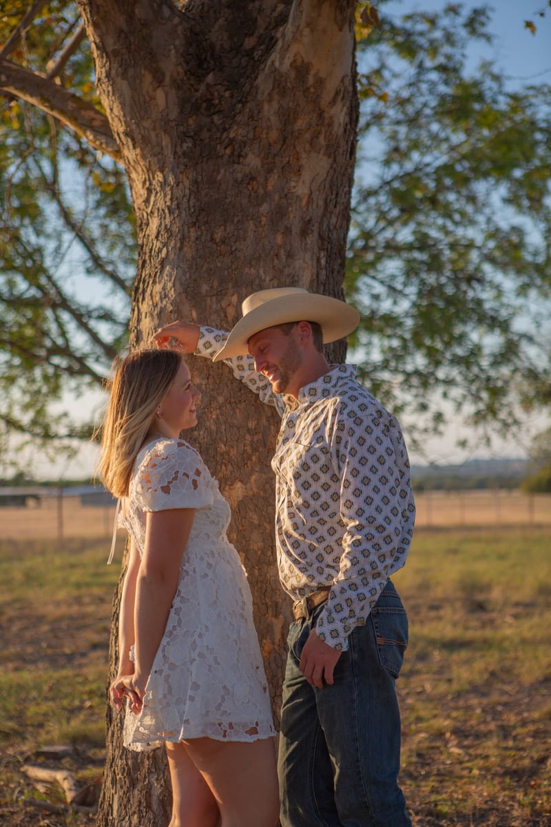 A couple standing under an oak tree