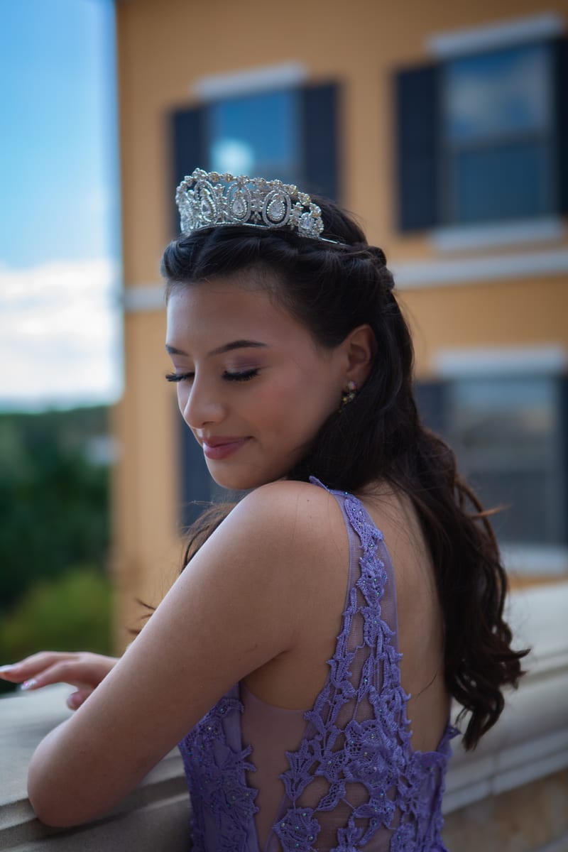 A girl in a tiara smiling over her shoulder