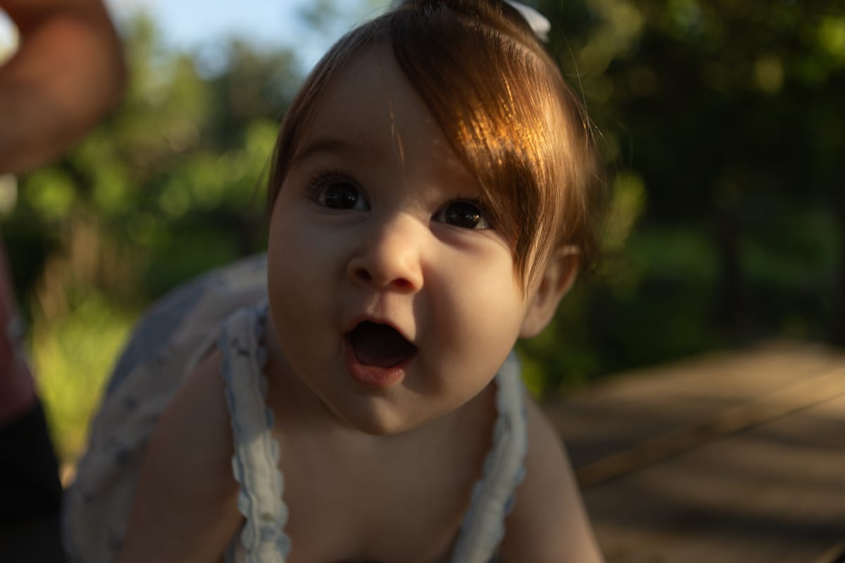 A baby with a surprised expression, outdoors
