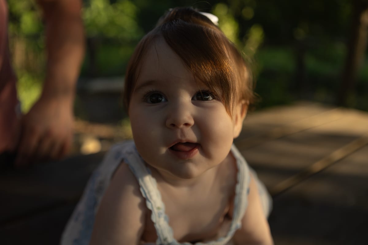 A baby looking up, warm light behind her