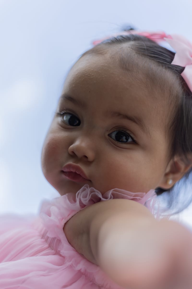 A baby in a pink tutu, close up