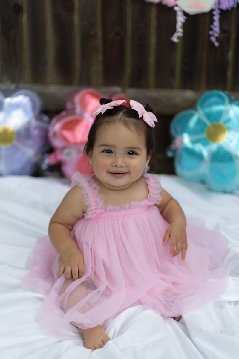 A baby in a pink tutu smiling