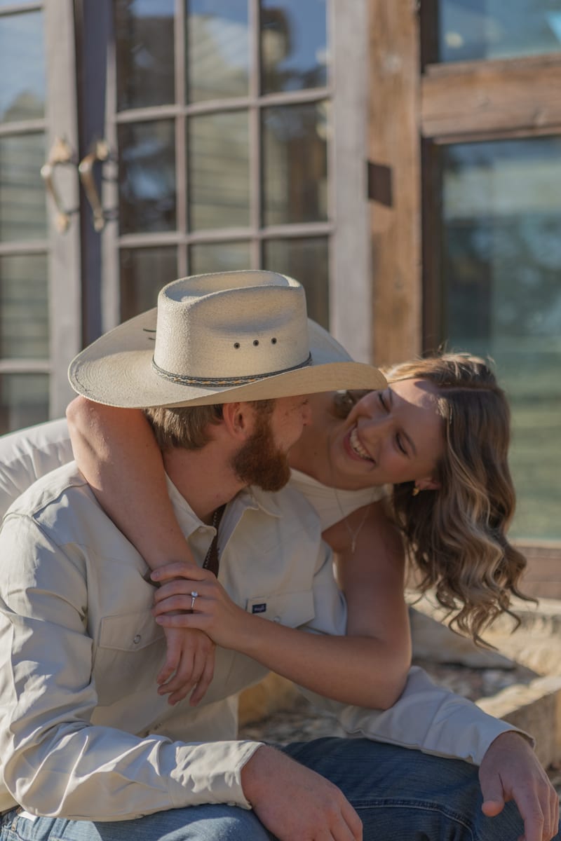 A couple kissing, his cowboy hat tipped back