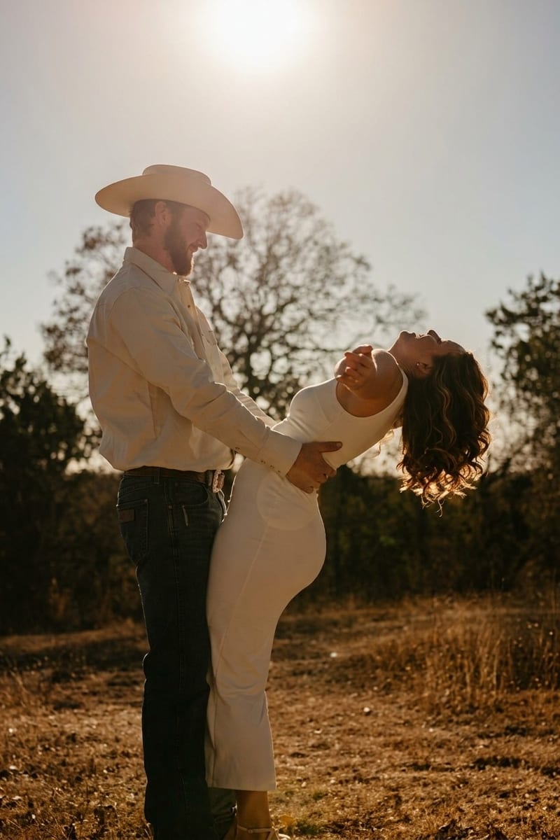 A couple at golden hour, he in a cowboy hat, she leaning back laughing, from an engagement session